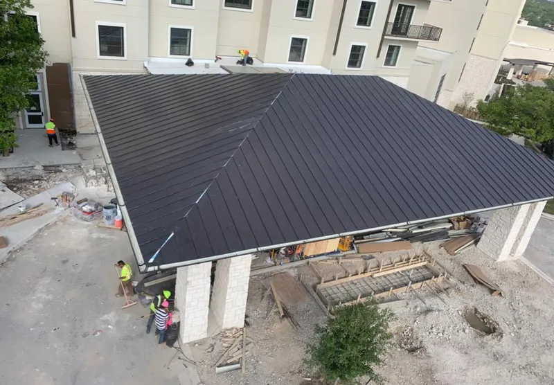 Metal roofing installation team working on a commercial building in St. Rose